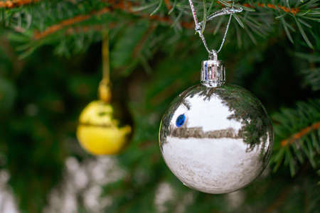 A silver mirror ball decorates a Christmas tree on the street in anticipation of the holidaysの写真素材