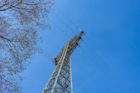 View from below of a power transmission tower against the sky. city infrastructure
