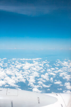 View of clouds and wing from airplane windowの写真素材