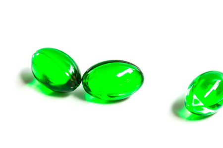 green capsules isolated on white backgroundの写真素材