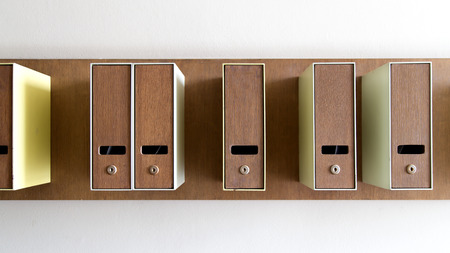 Mailboxes in color attached on the wall separated and randomly which light comes from right hand side, making shade and shadowの写真素材