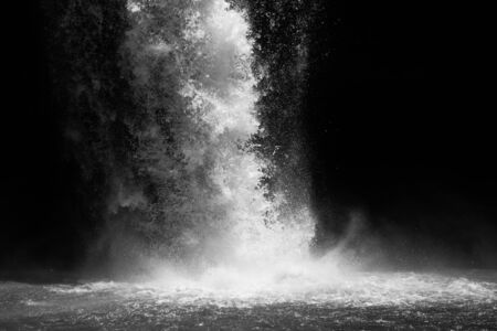 Water splashes on the ground under waterfall in black and white