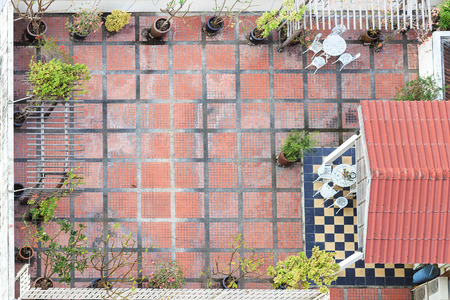 Aerial view on the old terrace with table and chairs which has small bush around the wall.の写真素材