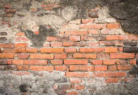 Old dark brown brick wall with crack from fire burning