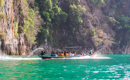 Suratthani, Thailand - April 14, 2015 : Travelling tourists travel by long trail boat with speed on...