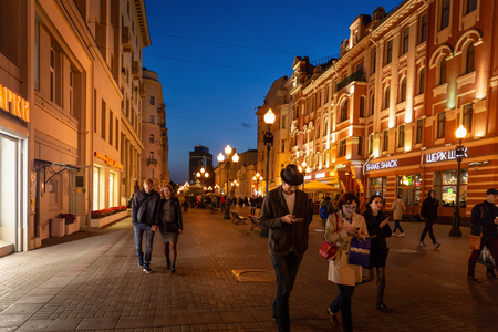 Moscow, Russia - September 21, 2017: People and historical building decorated by warm light at Arbat walking street during twilight with blue sky.のeditorial素材