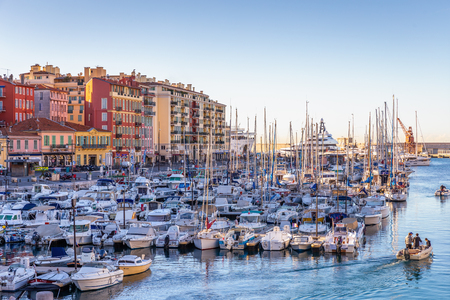 Nice, France - October 2, 2018: Morning scene of men sailing boat from boat parking area at port near colorful buildings of Nice, France.のeditorial素材