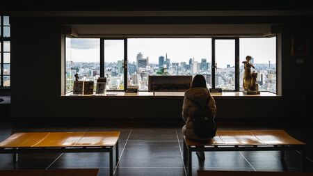 Kobe, Hyogo, Japan - November 22, 2018: Woman sit and watch aerial view of city in old building of Kitano town.のeditorial素材