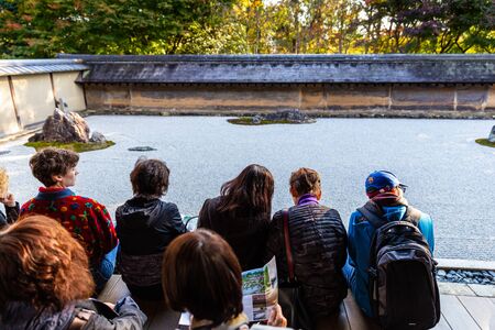 Kyoto, Japan - November 20, 2018: Tourist sitting quietly to watch famous rock garden in Ryoanji ancient temple.のeditorial素材