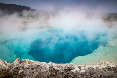Blue geyser basin with boiling water from geothermal heat, Yellostone National Park, Wyoming, USA....