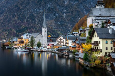 Hallsttt, Switzerland - November 2, 2019: Scenery of famous old village, world heritage Hallstatt, Austria. Hallstatt lake reflect town as mirror on water surface with dark background of mountain in early morning.のeditorial素材