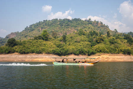Nakhon Nayok, Thailand - February 2, 2020 : Group of Thai people on orange life vest taking wooden speed boat with speed for sightseeing in Khun Dan Prakan Chon dam.のeditorial素材