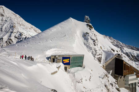Jungfrau, Switzerland - November 9, 2019: Tourists walking out for outdoor activities from Jungfraujoch observation building on saddle of snow capped mountain of Jungfrau.のeditorial素材