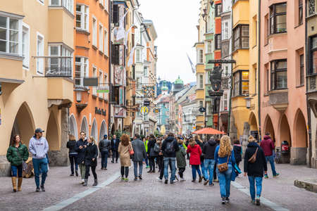 Innsbruck, Austria - November 3, 2019: Tourists walking on street surrounding by colorful houses and buildings in old walking street.のeditorial素材