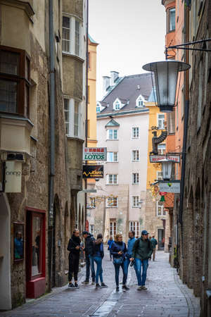 Innsbruck, Austria - November 3, 2019: Tourists walking on street surrounding by old houses and buildings in walking street.のeditorial素材