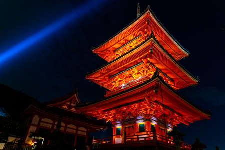 Kyoto, Japan - November 21, 2018 : Ancient red pagoda tower decorated by orange light under ceilings of Kiyomizu Dera temple at night.のeditorial素材