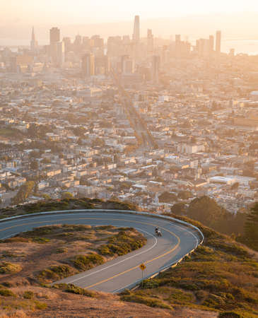 Aerial view over misty city of San Francisco, California, USA with curved road on twin peaks view point in morning.の写真素材