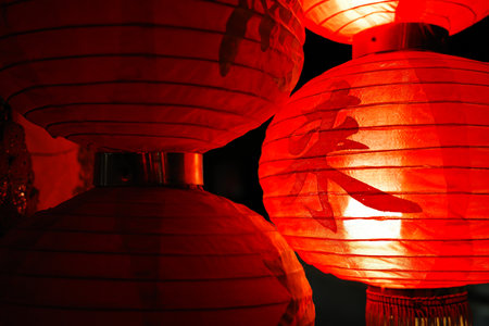 Low key scene of chinese red paper balloon lamp with chinese letters meaning of tea restaurant and shining bright light insight in dark night.の写真素材