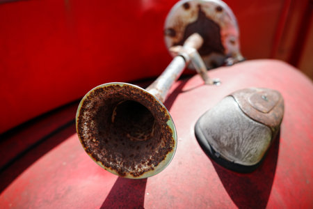 Close focus on rusty metal car horn designed and fixed in front of car body.の写真素材
