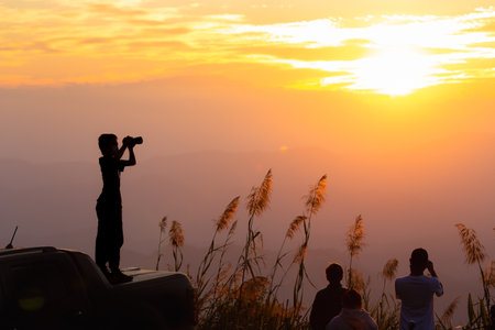 Chiangmai, Thailand - December 31, 2021: Silhouetted scene of boy standing on truck with camera and...