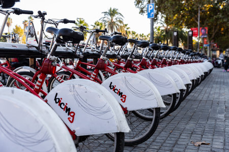 Bacelona, Spain - October 5, 2018: Bicycles with white wheel cover hanging on parking rack for...