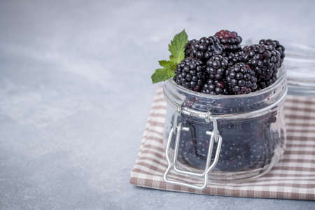 Closeup of fresh blackberries in a bowl on the napkinの写真素材