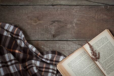 Vintage book, cup of tea, old flowers, plaid. Composition on the wooden background. Flat lay.の写真素材