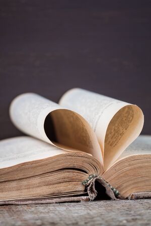 An old book with heart-shaped pages, vertical viewの写真素材