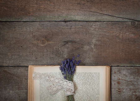 Vintage book, a bunch of lavender. Composition on the wooden background. Flat lay.