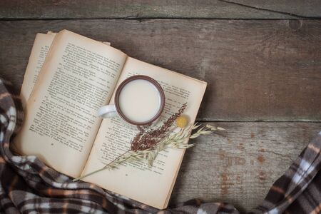 Vintage book, cup of tea, old flowers, plaid. Composition on the wooden background. Flat lay.の写真素材