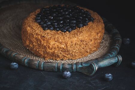 Homemade honey cake with blueberries on the dark backgroundの写真素材