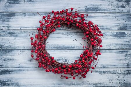 Christmas wreath with red berries on the wooden backgroundの写真素材