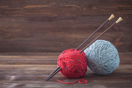 Red and grey tweed wool yarn with wooden knitting needlesの写真素材