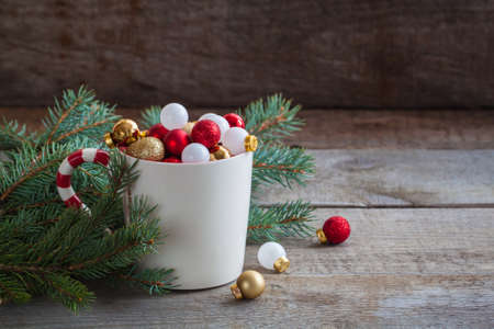 Christmas toys balls in a cup on a wooden background. Toned. Copy spaceの写真素材