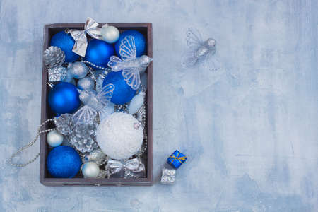 Christmas postcard decoration set silver white and blue balls toys cones presents in the wooden box. Vertical.の写真素材