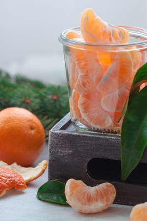 Fresh tangerines with leaves and a branch of a fir tree. Russian Christmas and New year traditionの写真素材