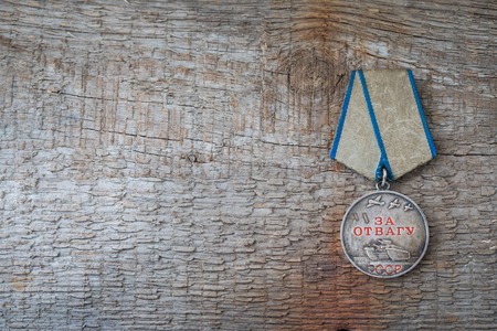 The Old Soviet Medal For Bravery of the Second World War with a red carnation, Victory Day May 9 postcard concept, toned vintageの写真素材