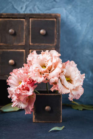 Pink garden carnations in the old box on dark background, postcard or wedding invitation conceptの写真素材