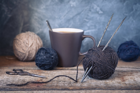 Beige, grey and brown yarn balls on a rustic wooden background, tonedの写真素材