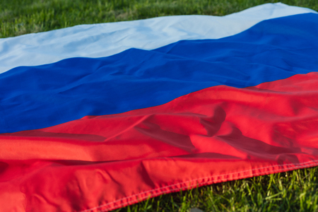 Russian flag lying on the green grass, tonedの写真素材