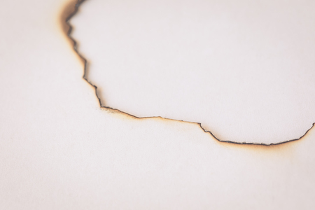 Old paper with burnt hole, background concept, toned vintageの写真素材
