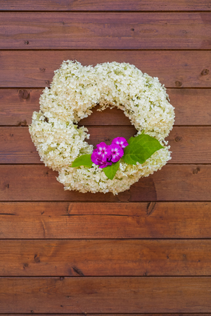 A wreath of white hydrangea on the wooden background, tonedの写真素材