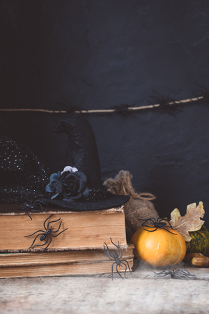 Halloween holiday background with pumpkin, lantern, spiders, old books, black witchhat, tonedの写真素材