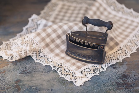 Hot, vintage old iron with coal on linen fabric, toned