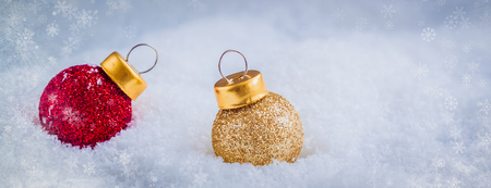 Christmas composition with red and golden toys on the snow, copy space for text, snowflakes frame textureの写真素材