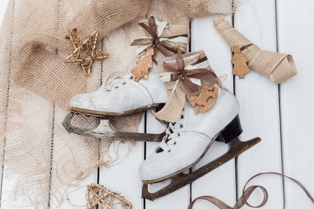 Top view of stages of making Christmas decoration of old vintage ice skates with ribbons, toned