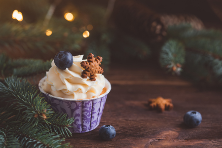 Tasty blueberry muffins with cream on wooden table, Christmas dessert, tonedの写真素材