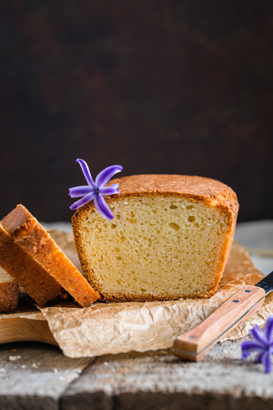 Tasty homemade baked traditional cake with a blue hyacinth potted on wooden baclgroundの写真素材