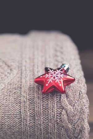 Stack of cozy knitted sweaters on a wooden table. Retro style. Warm concept, toned, Christmas backgroundの写真素材