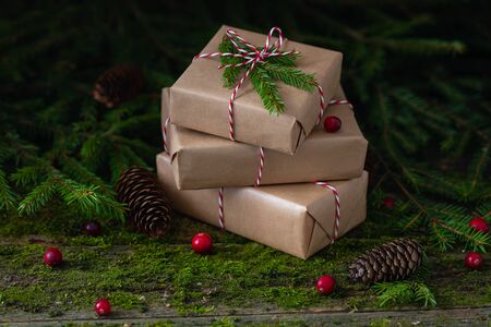 New Year Christmas composition with a pile of presents wrapped in craft paper on natural moss...